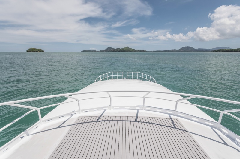 Wide-angle view of Phuket Island from a catamaran, showcasing clear skies and calm waters."