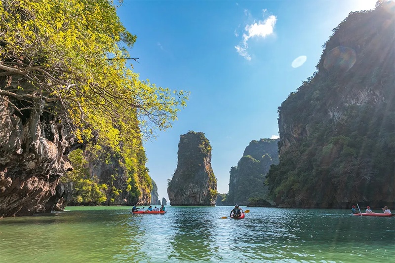 Tourists kayaking through the scenic waters of Hong Island, Phuket, surrounded by towering limestone