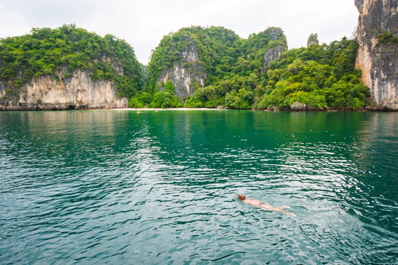 A person swimming in the serene, clear waters off the coast of Hong Island, Phuket.
