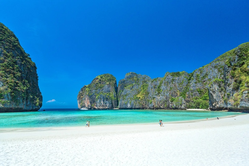Phi Phi Island beach with pristine white sand and turquoise water under a clear sky.