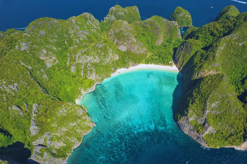 Exploring Phi Phi Island´s natural beauty with tropical plants, clear water, and rocky cliffs.