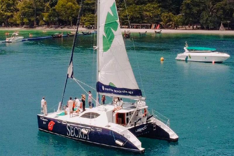 Experience the luxury of a private sailing boat with a stunning beach backdrop.