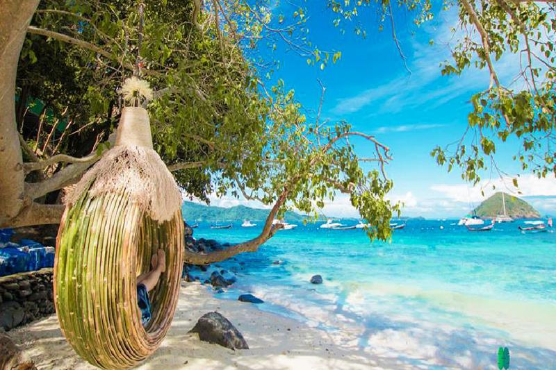 Relax on a tropical beach in a cozy hanging chair, perfect for a peaceful retreat.