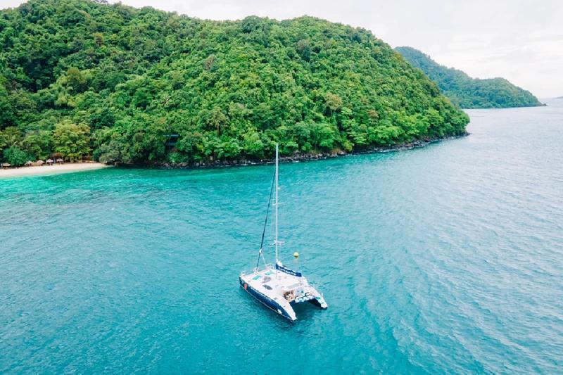 Private sailing boat surrounded by lush greenery, perfect for a peaceful escape.