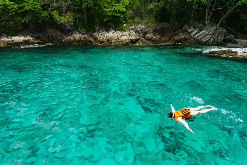 Scenic view of Racha Island with clear blue skies, lush green hills, and crystal-clear waters perfec