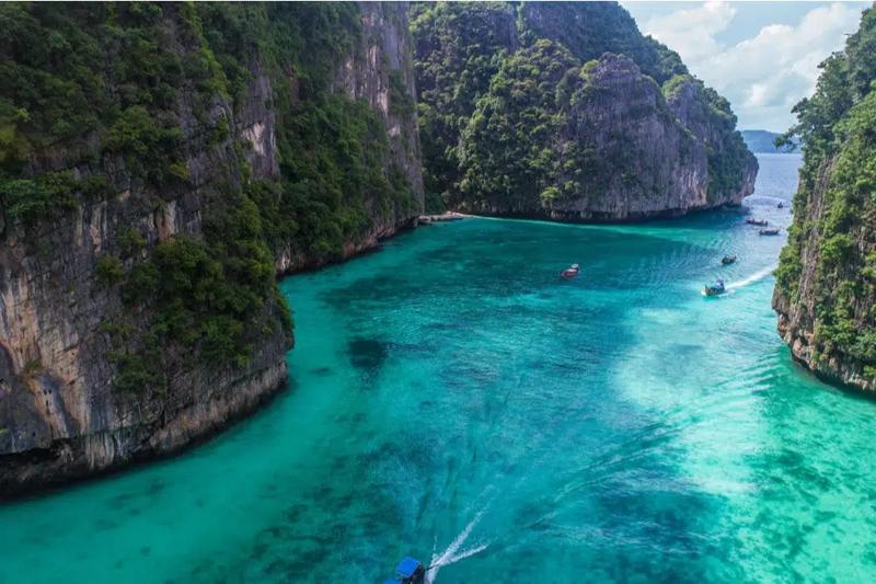 Stunning turquoise waters of Pileh Lagoon surrounded by high limestone cliffs on Phi Phi Islands.