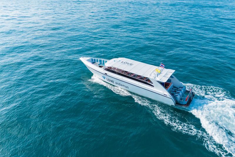 A Love Andaman speed boat named Irena cruising through the turquoise waters, with a sleek design and