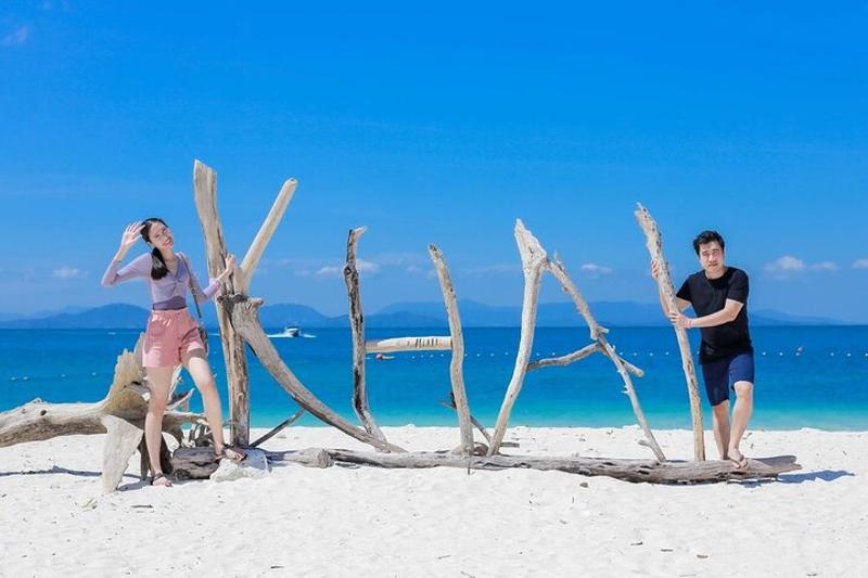 A scenic beach in Phuket with golden sand and clear blue water, perfect for sunbathing and relaxatio