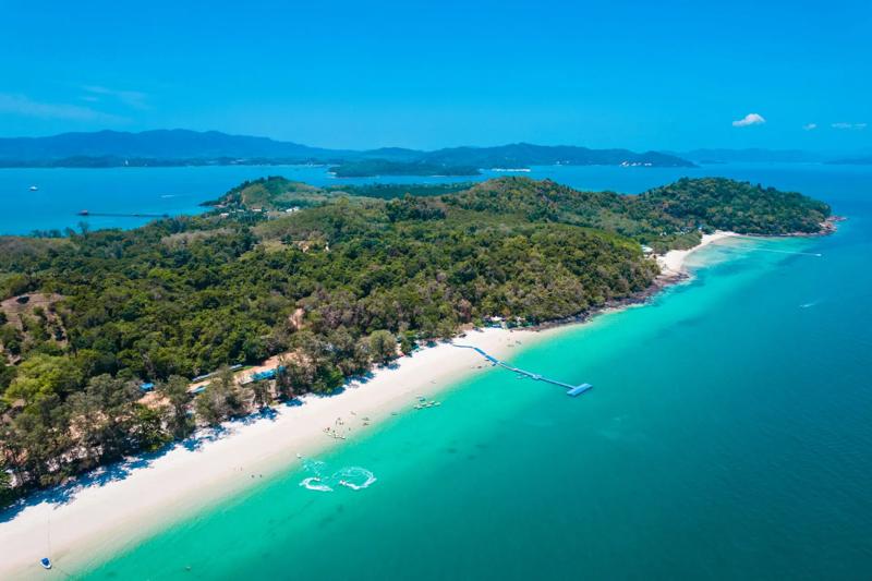 A breathtaking aerial view of a tropical island in Phuket, Thailand, with clear turquoise waters and