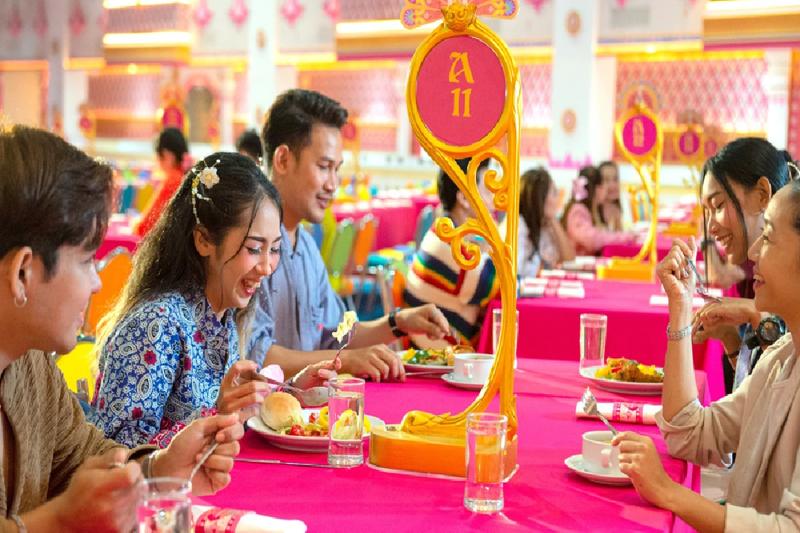 Group of people enjoying a meal at a brightly decorated restaurant.