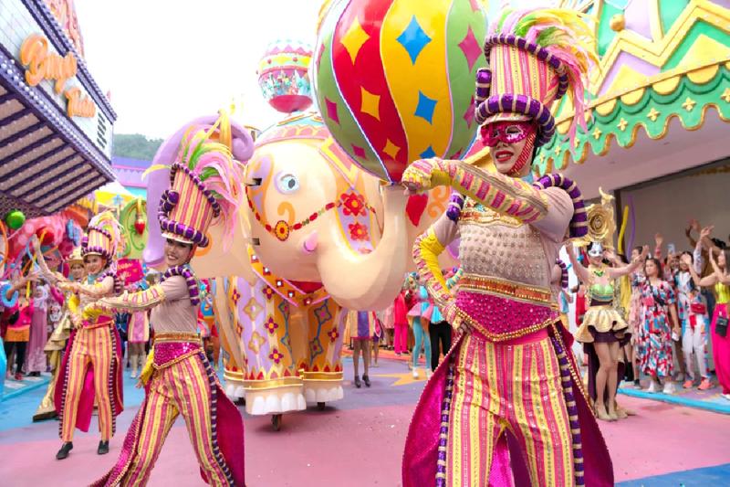 Carnival performers in colorful costumes dancing with balloons in a vibrant parade.