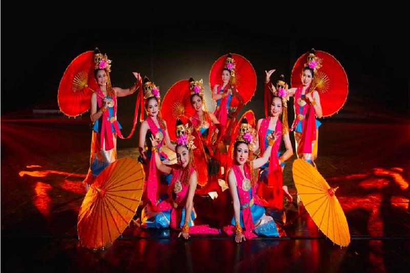 A vibrant dance parade featuring performers in golden costumes at Phuket Fantasea.