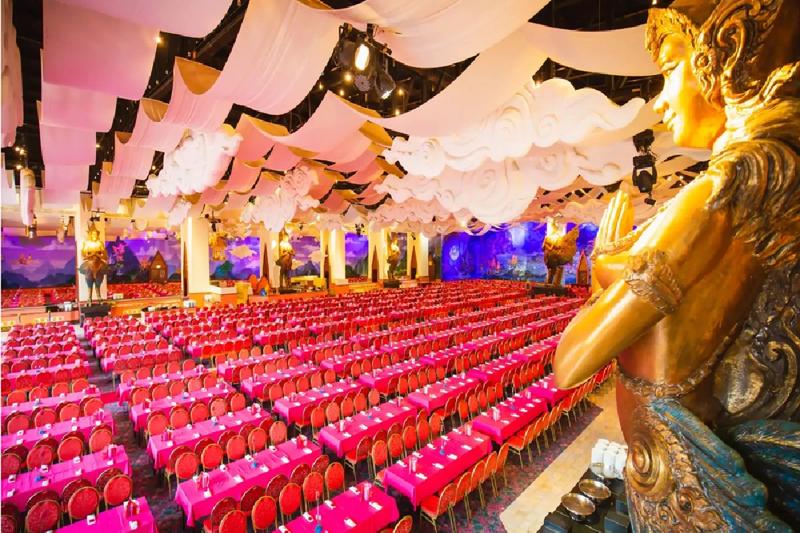 The grand dining hall at Phuket Fantasea with rows of tables and elegant decorations.