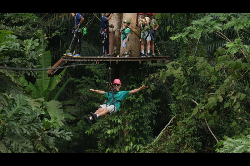 A group of adventurers crossing a high-rope bridge at Hanuman World, experiencing the ultimate canop
