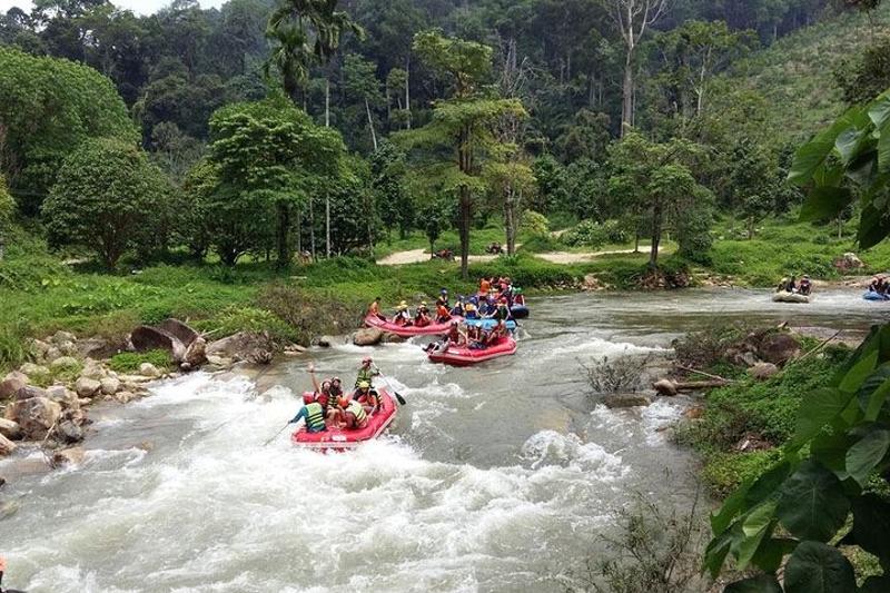 Group of people rafting on fast-moving river in tropical rainforest